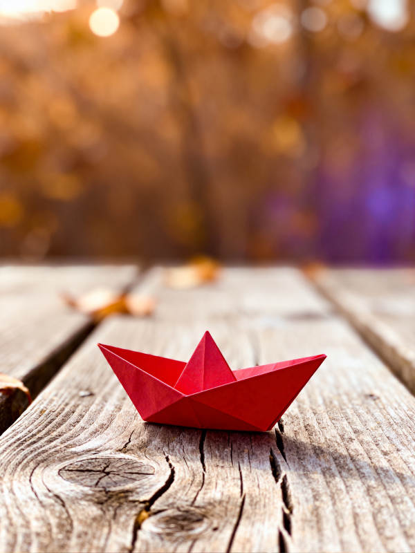 红纸船静置于木桌图片