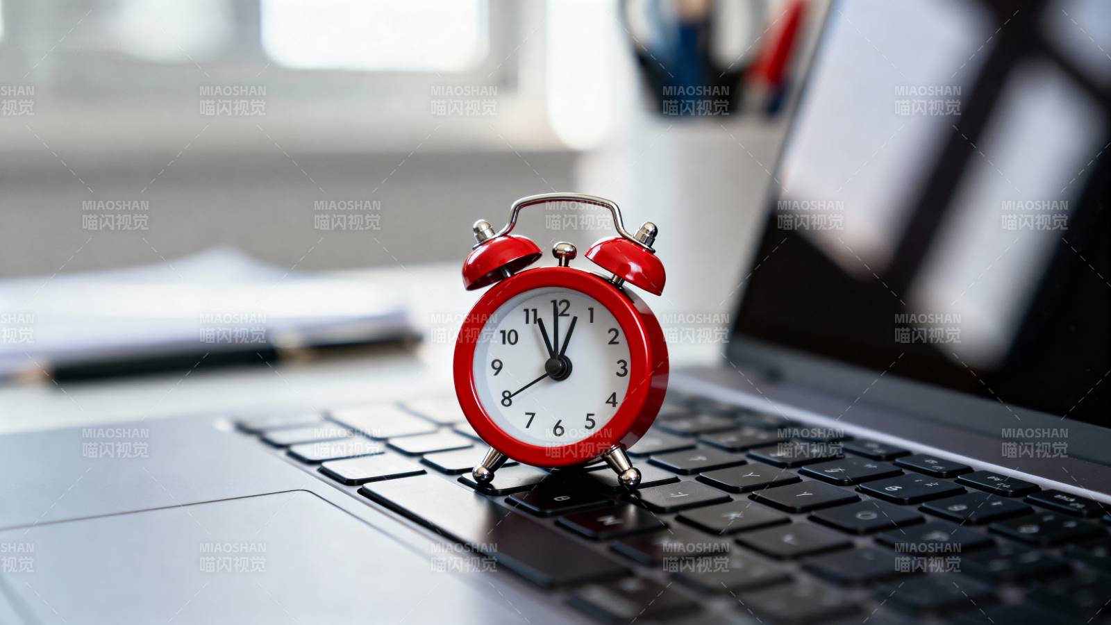 闹钟置于笔记本上图片