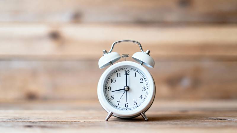 复古闹钟静置木桌图片