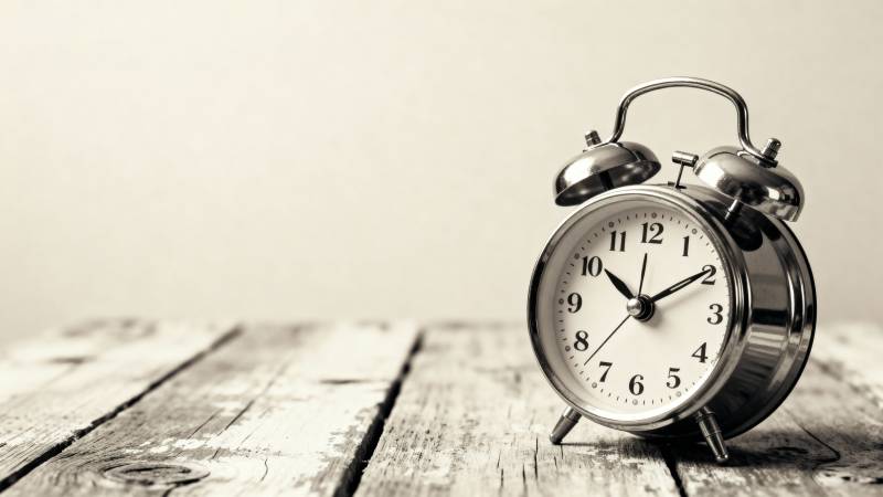 复古闹钟静置木桌图片