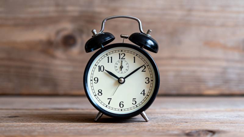 复古闹钟静置木桌图片