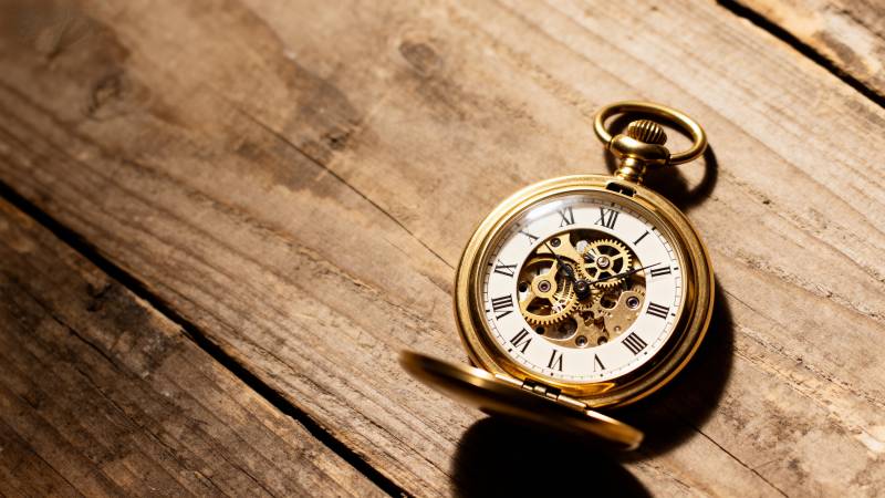 古董怀表静置于木桌图片