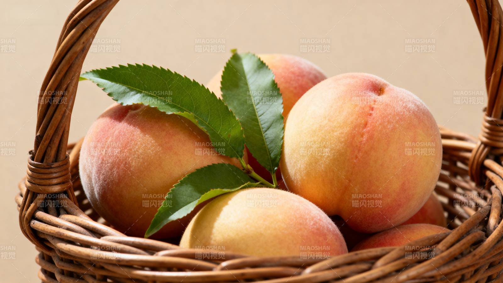 篮中鲜桃绿叶相伴图片