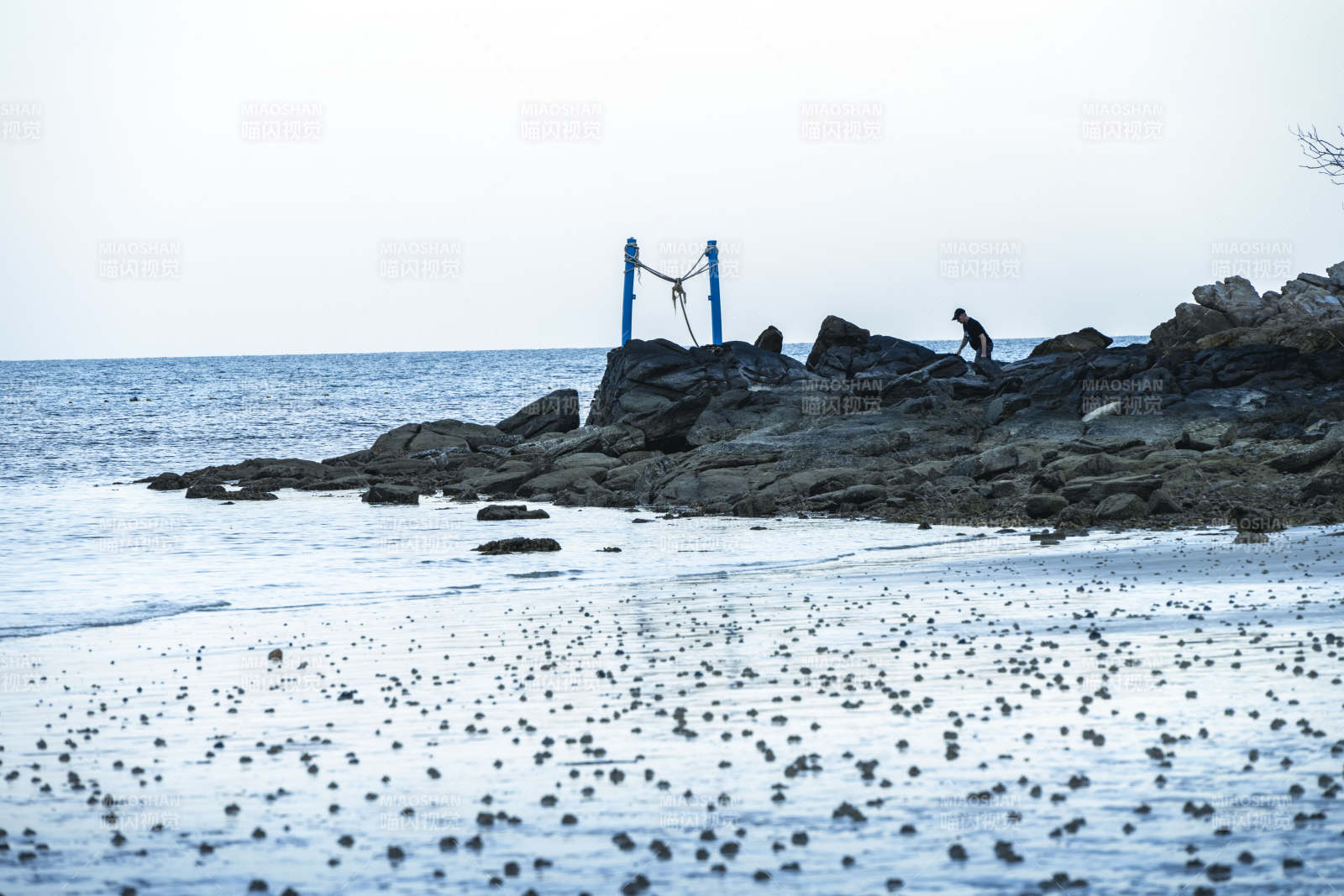 海边岩石上的身影图片