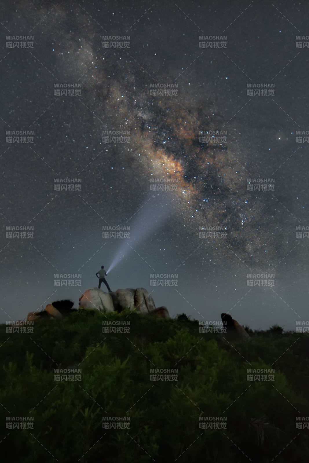 星空银河下的一个人举着探照灯图片