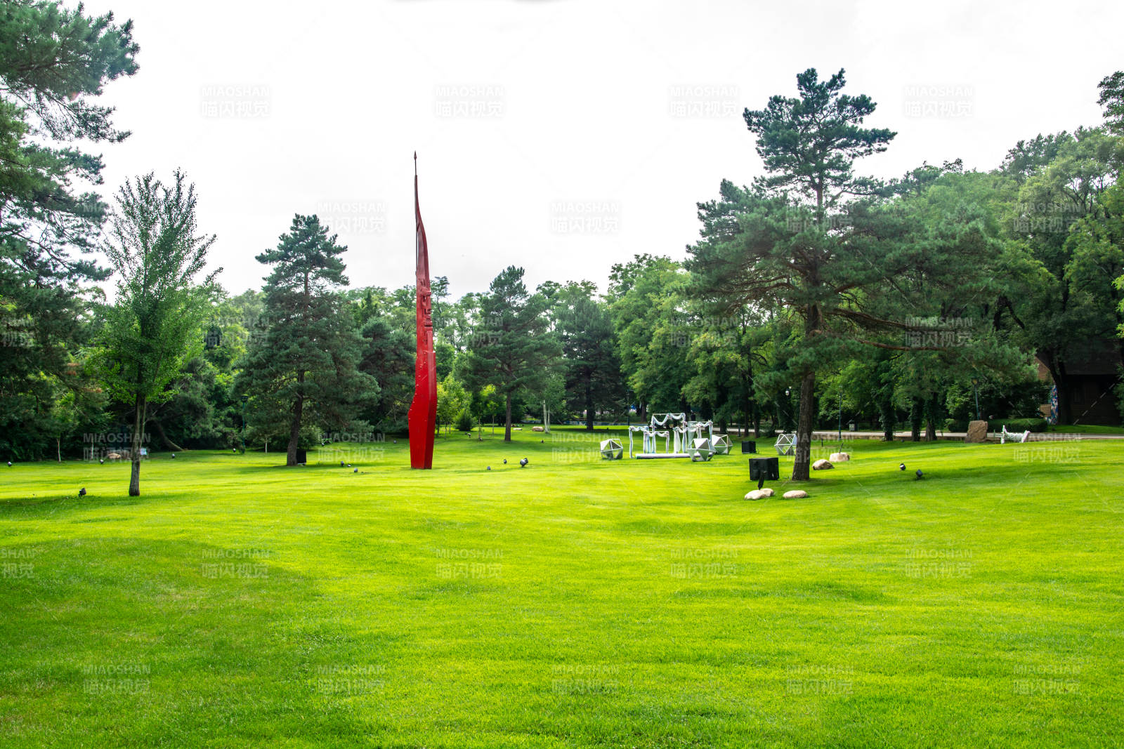 绿茵中的红色雕塑图片
