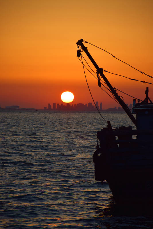 夕阳下的渔船剪影图片