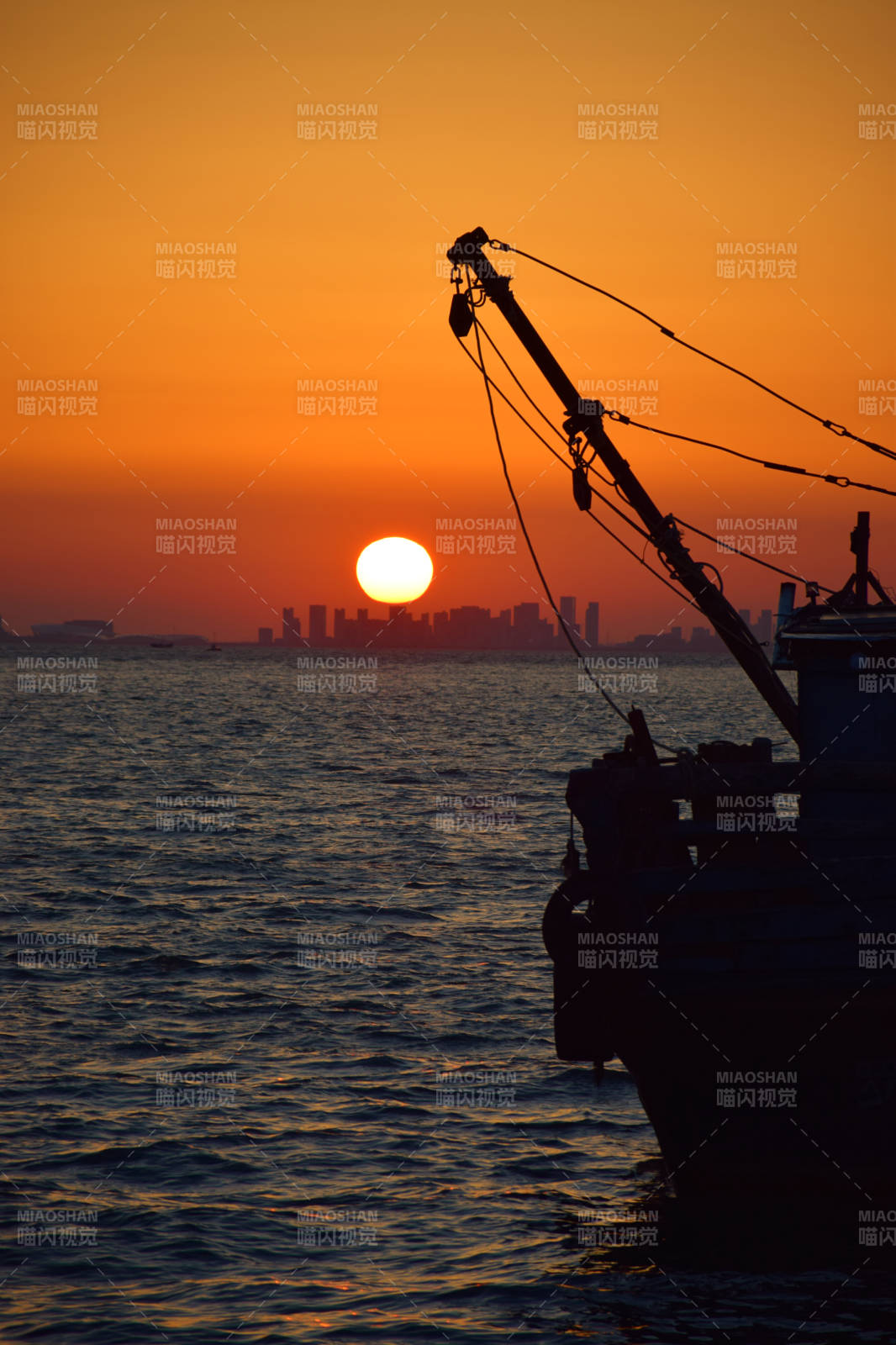 夕阳下的渔船剪影图片