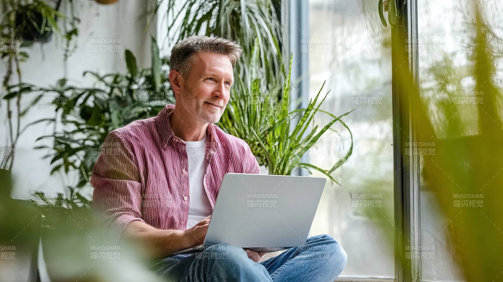 窗边办公的男子图片