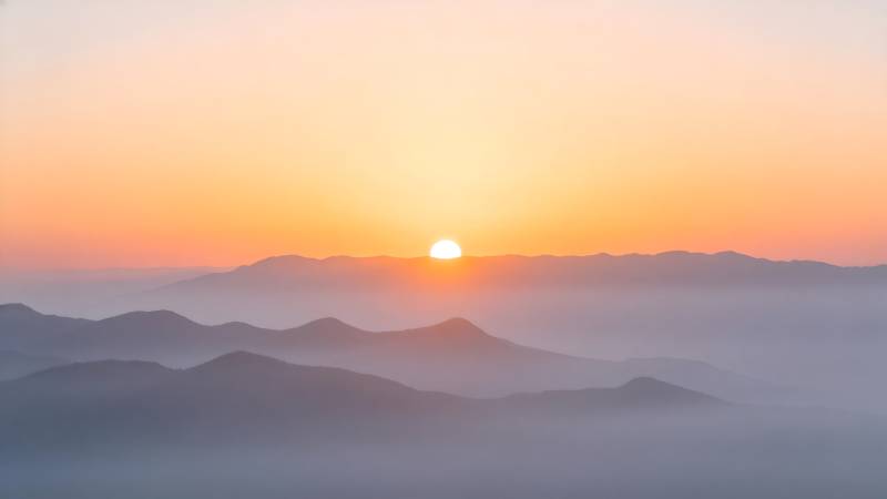 日出山峦间图片