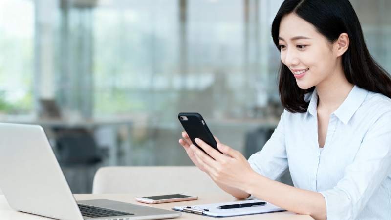 办公桌前微笑看手机图片