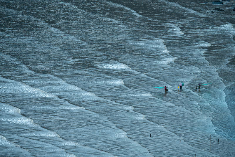 福建霞浦小皓海滩蓝色波纹和赶海的渔民图片