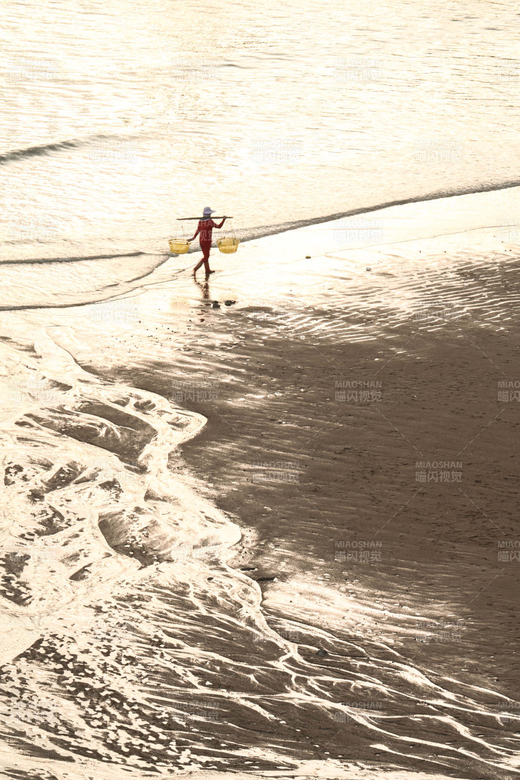 海边挑担人图片