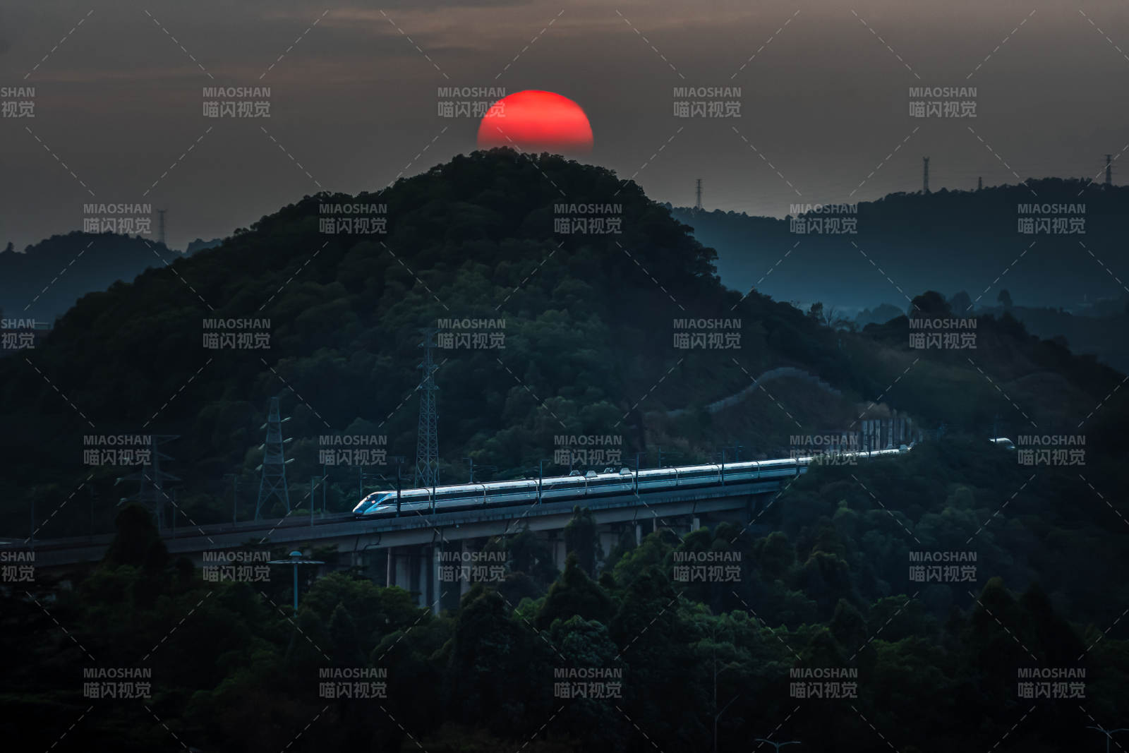 夕阳下的高铁穿山而过图片