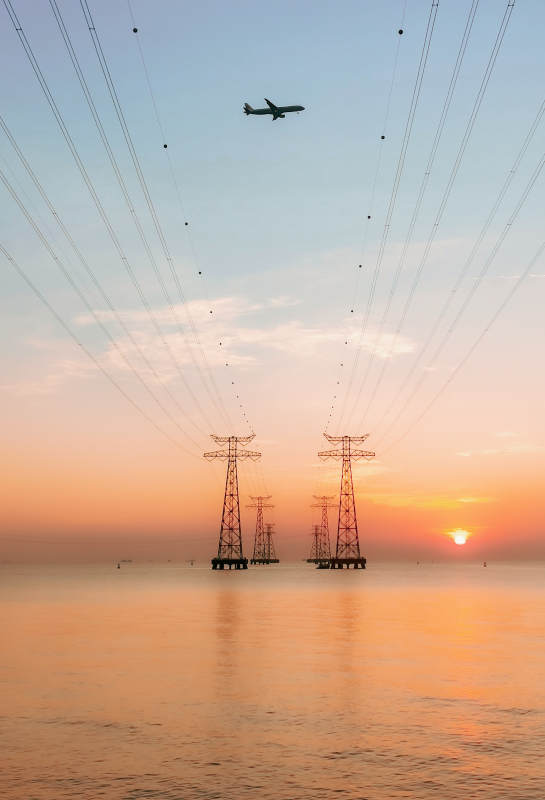 日落海天电塔航迹图片