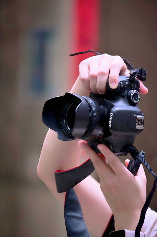 手持佳能相机拍摄图片