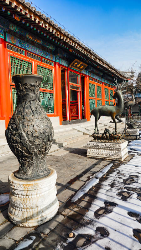 古建筑前的铜鹿与花瓶图片