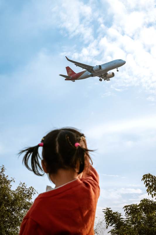 小女孩仰望飞机图片