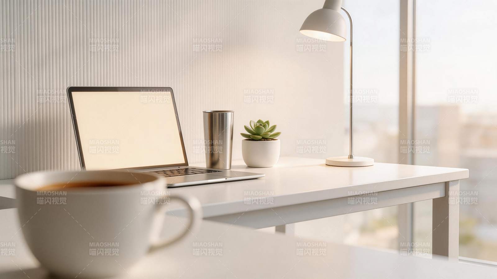 白色办公桌上摆放笔记本电脑与绿植咖啡杯图片