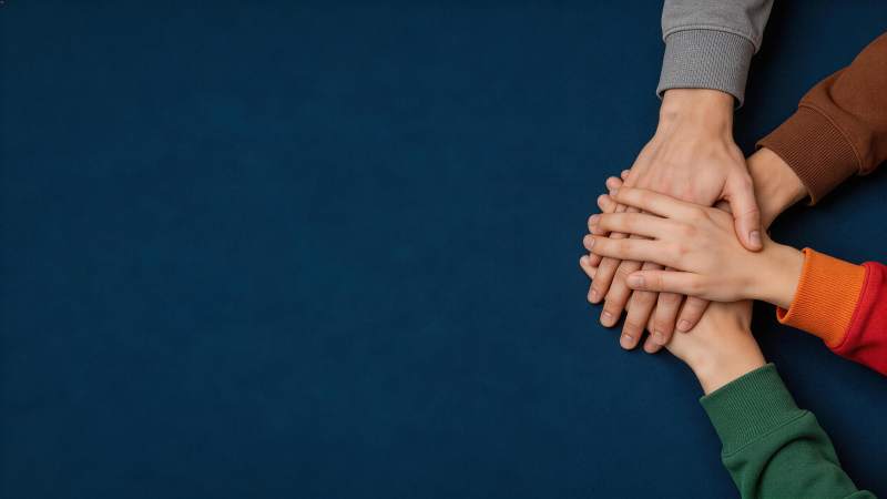 多人叠手象征团结协作的特写画面图片