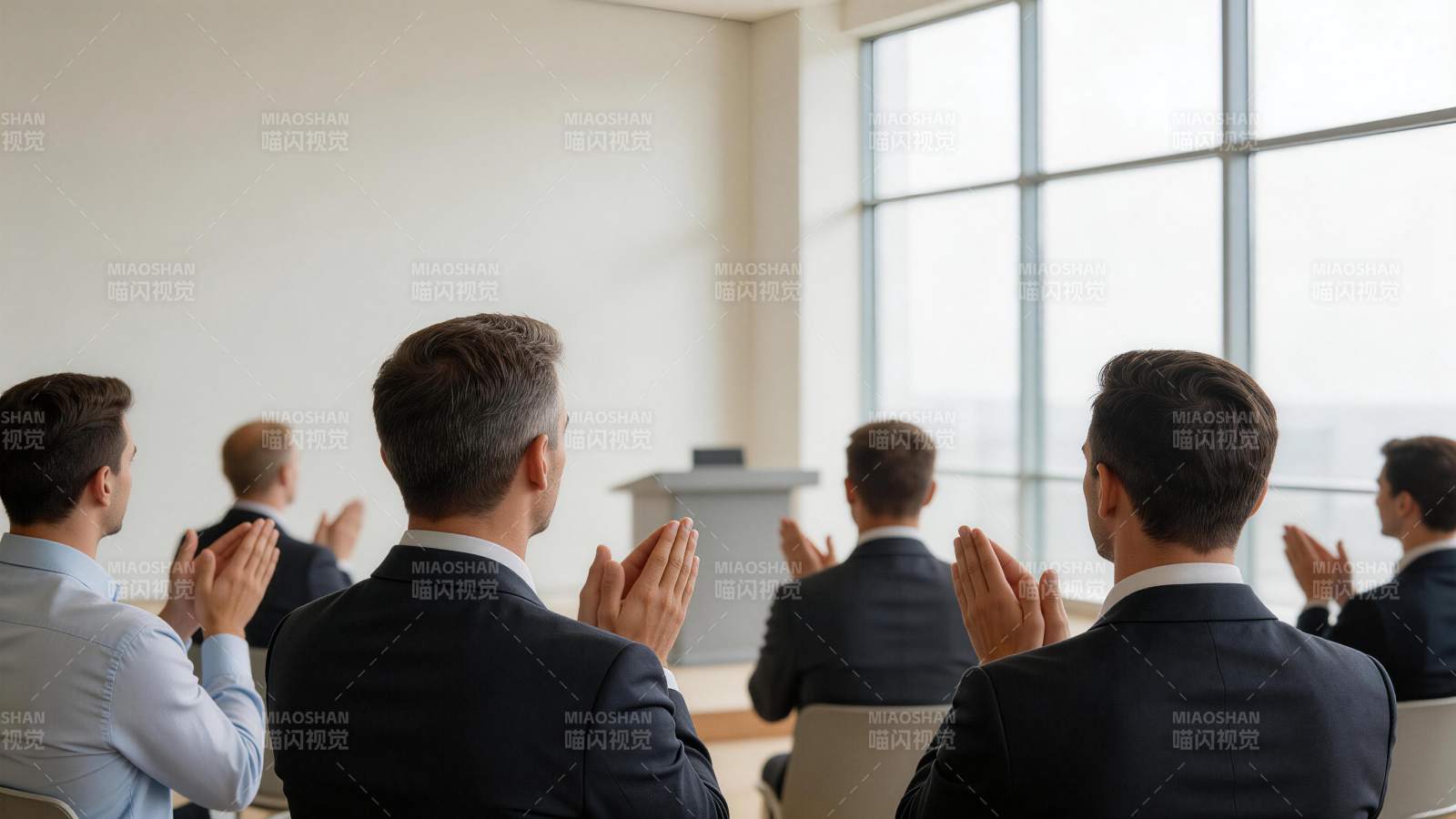 多位男士背对镜头鼓掌聆听演讲图片