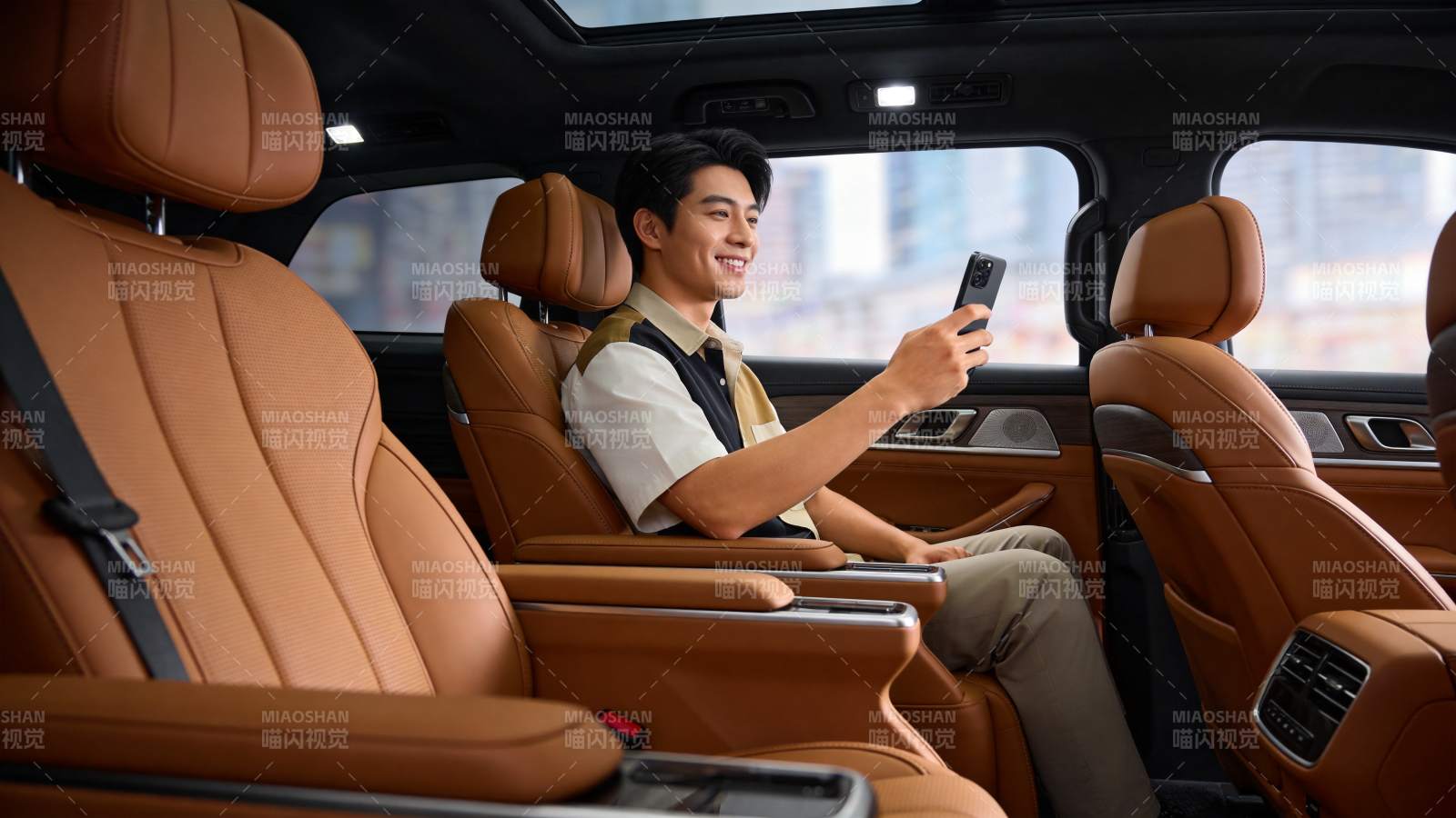男子坐在豪华车内手持手机微笑图片