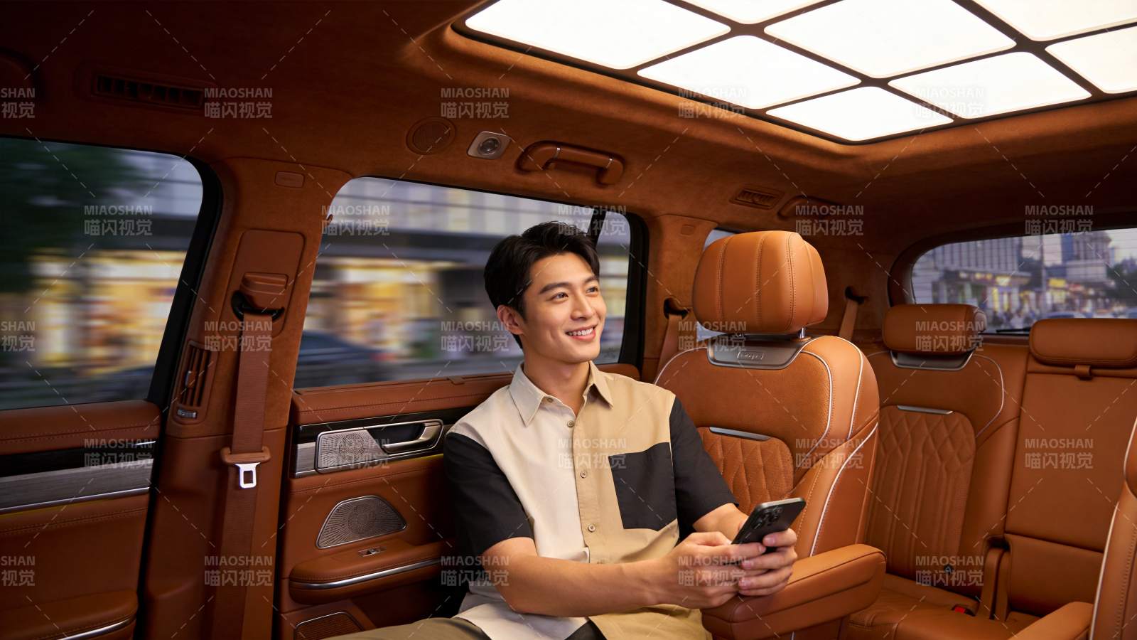 男士乘坐豪华车内手持手机微笑望向窗外图片
