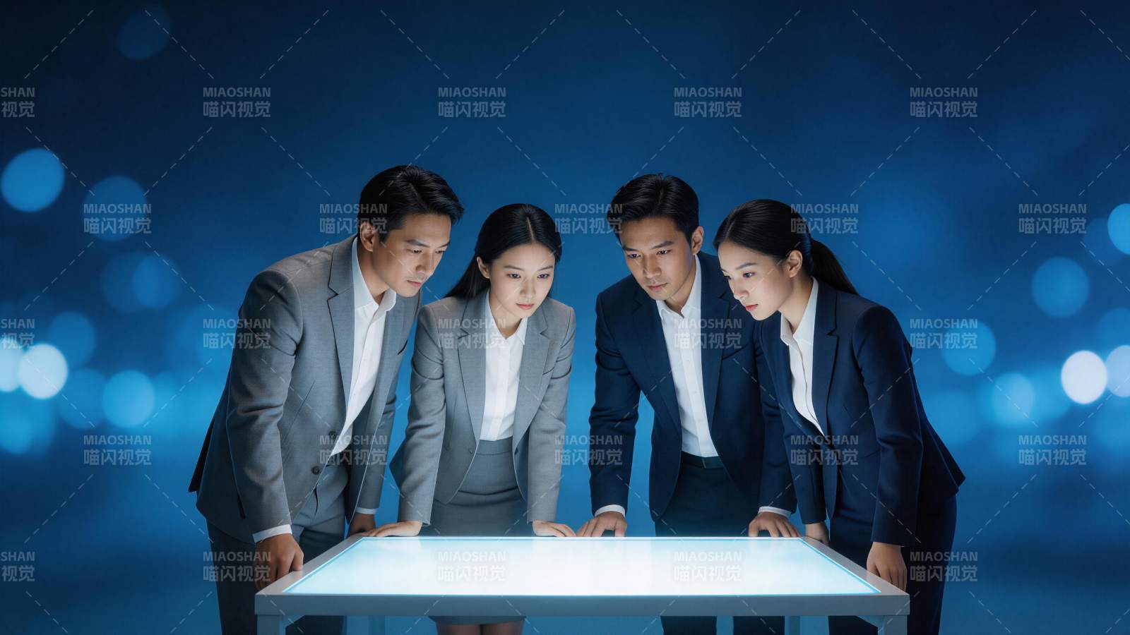 四位商务人士围看发光交互桌面进行协作图片