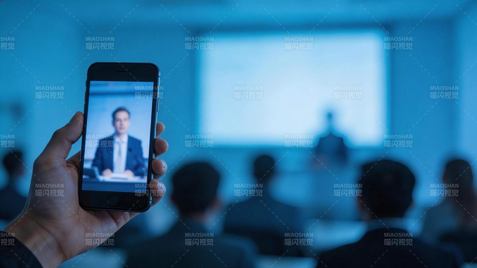 手持手机拍摄会议现场演讲者画面图片