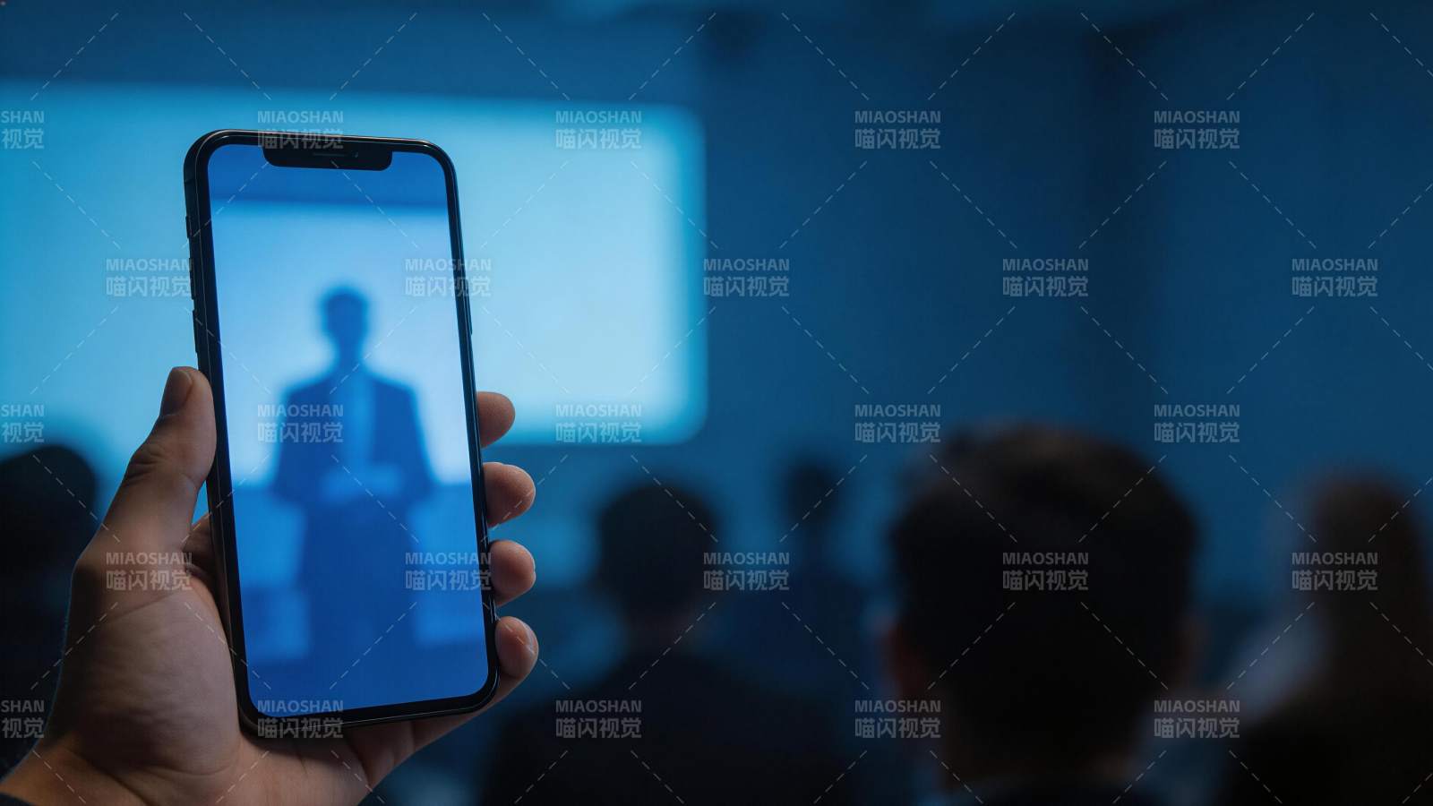 手持智能手机拍摄会议投影屏幕场景图片