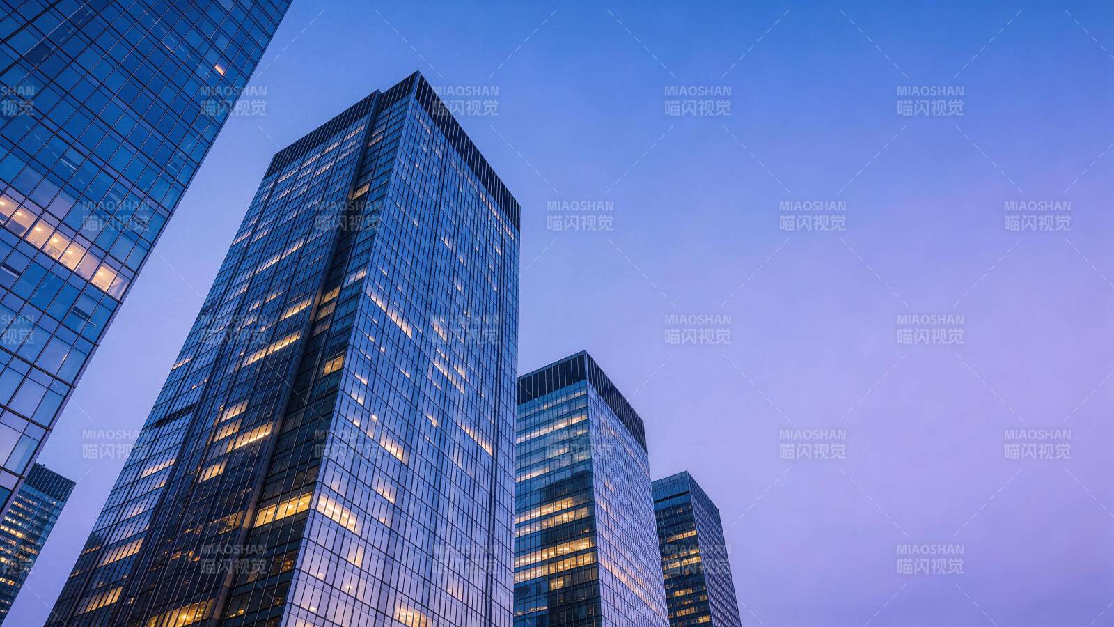 黄昏时分玻璃幕墙摩天大楼群仰拍景象图片