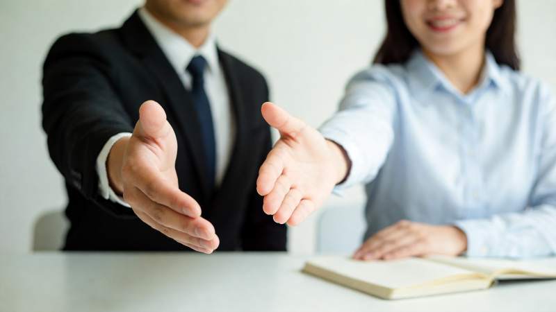 商务人士双手前伸准备握手场景图片