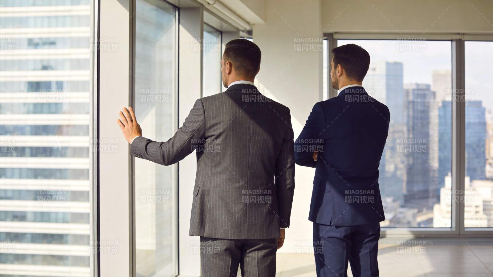 两位西装男士背对镜头眺望城市高楼景观图片