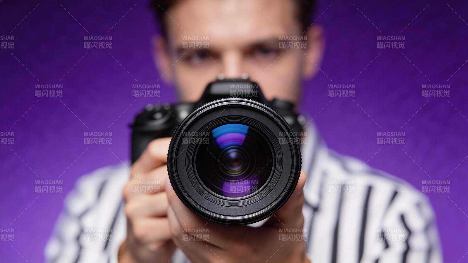 摄影师手持相机对准镜头拍摄特写图片