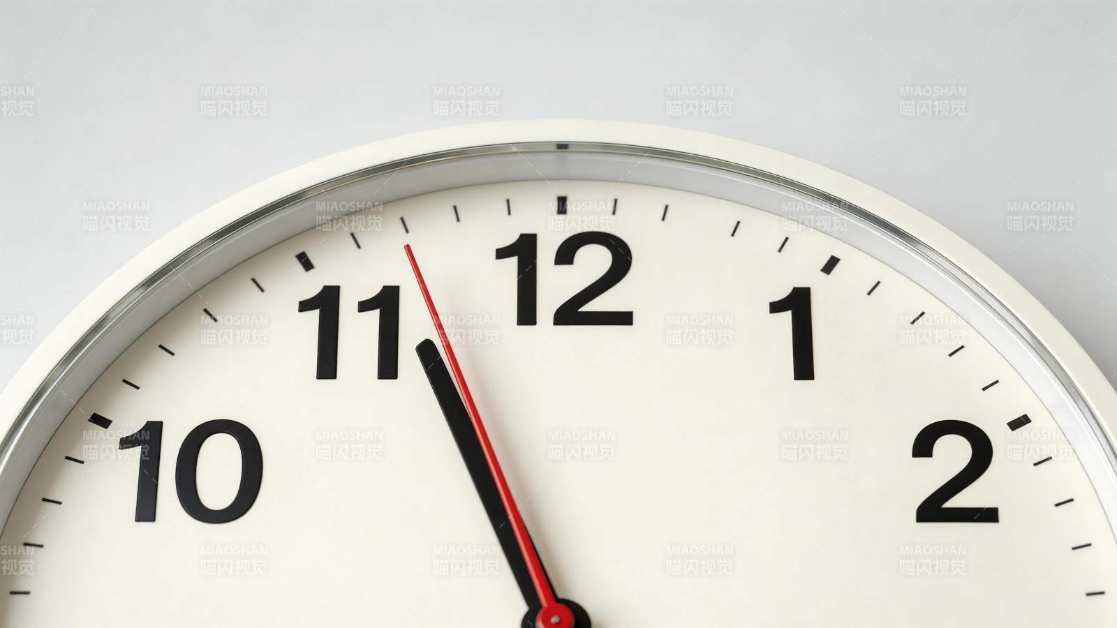 白色圆形挂钟特写显示时间接近十二点图片