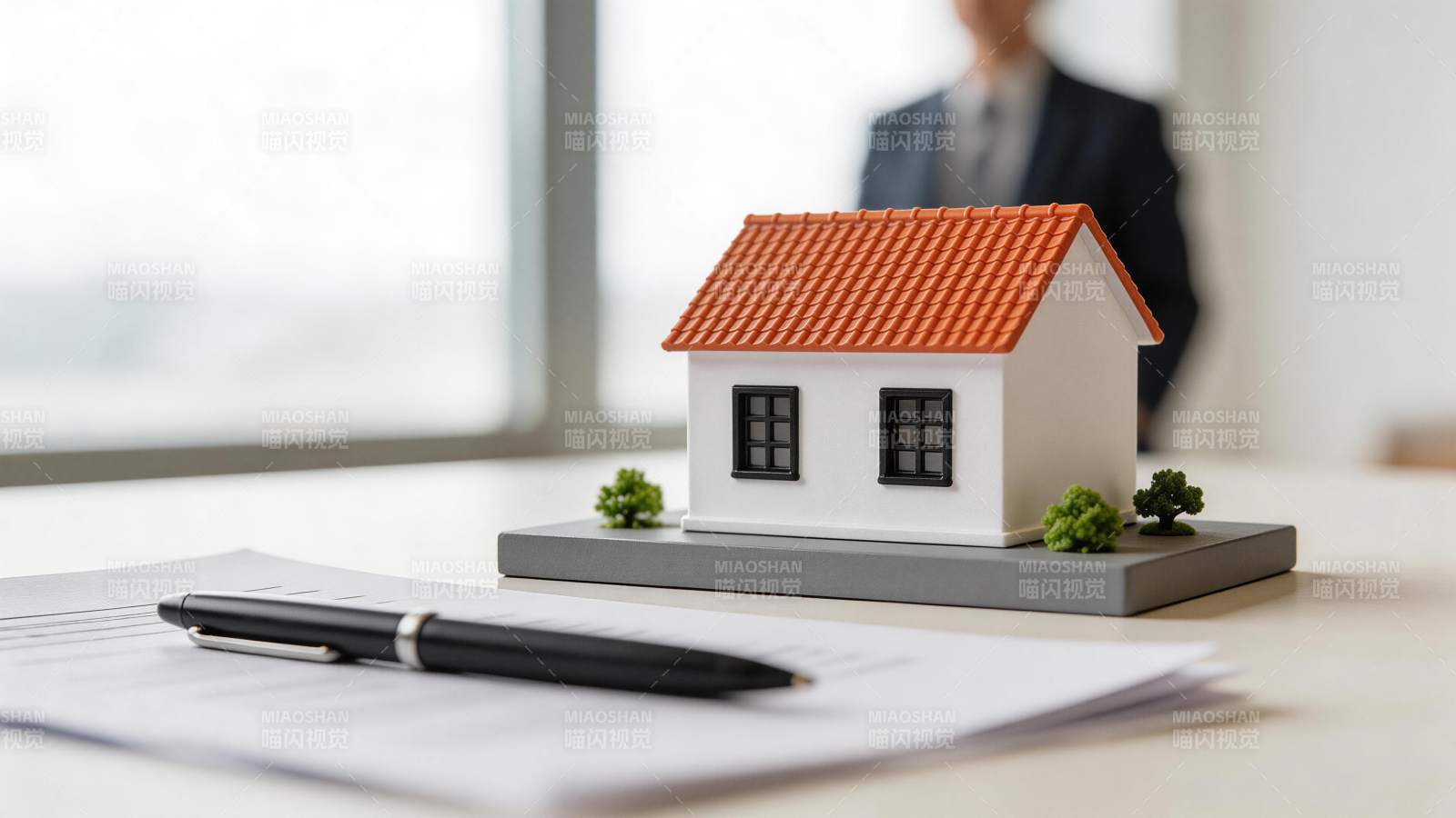办公桌上房屋模型与合同文件特写图片