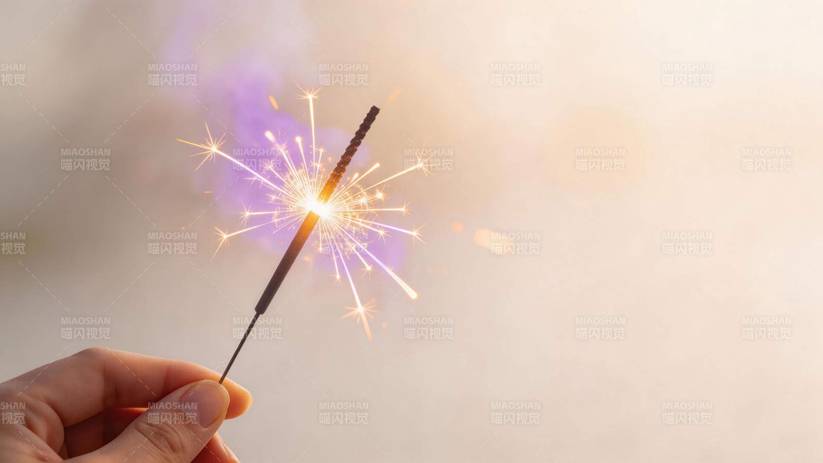 手持点燃的烟花棒发出耀眼火花图片