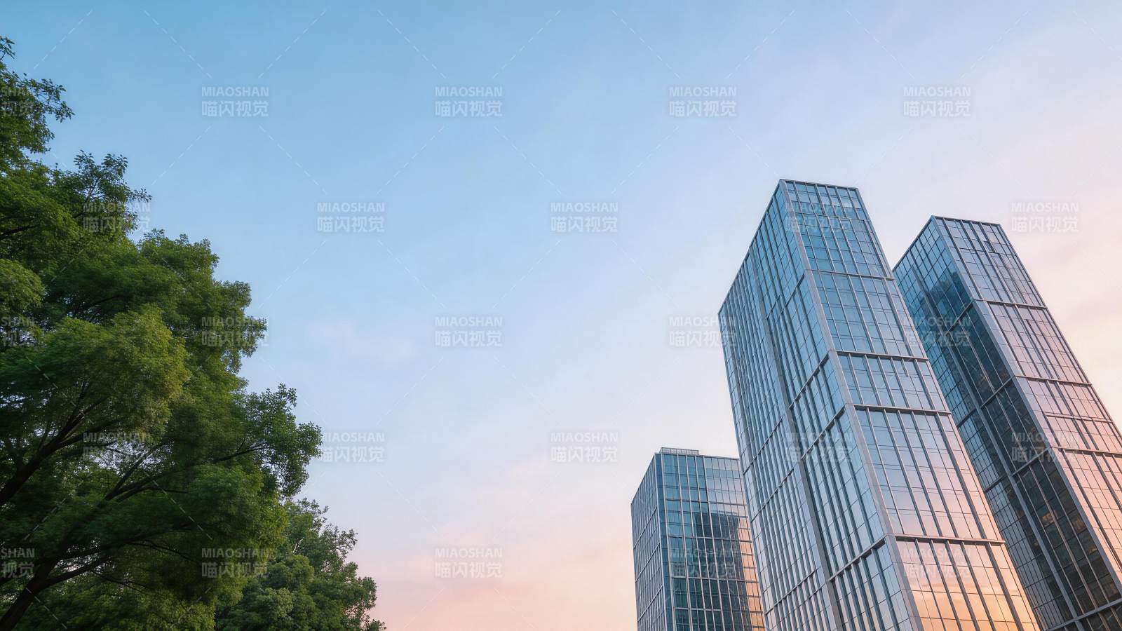 现代玻璃幕墙高楼与绿树映衬的都市天际线图片