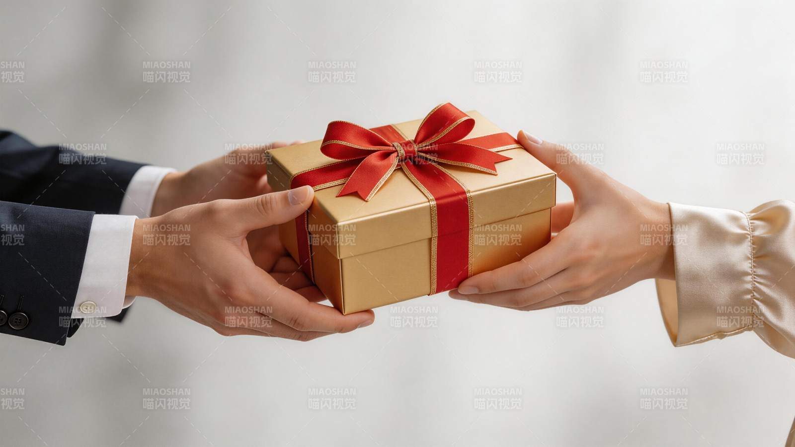两人交接系红丝带金色礼盒的特写画面图片