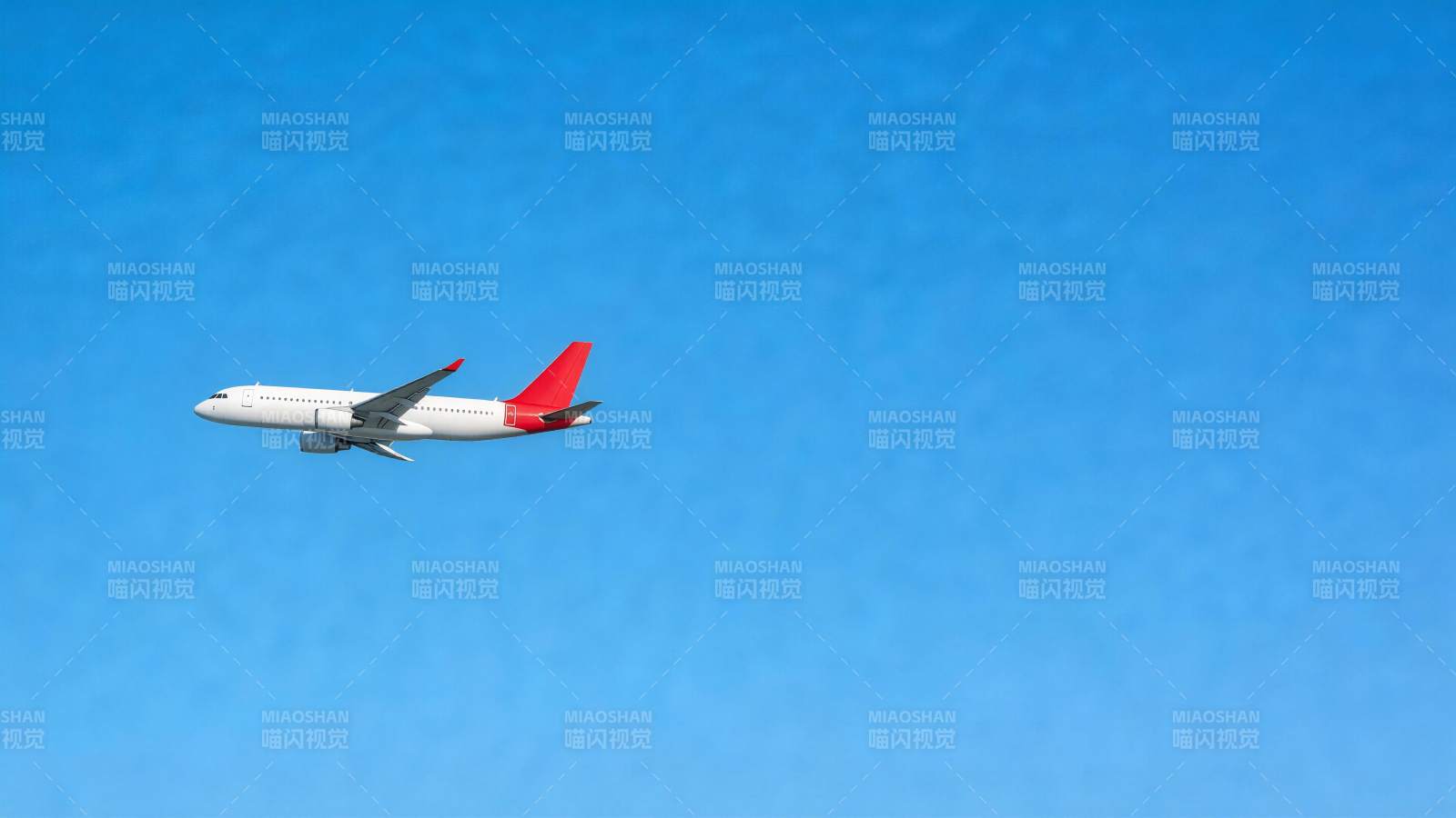 白色客机红尾翼蓝天飞行中图片