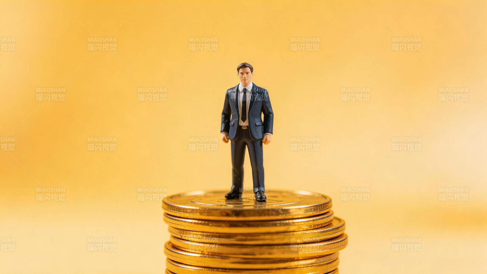 西装小人模型站立在金币堆顶部图片