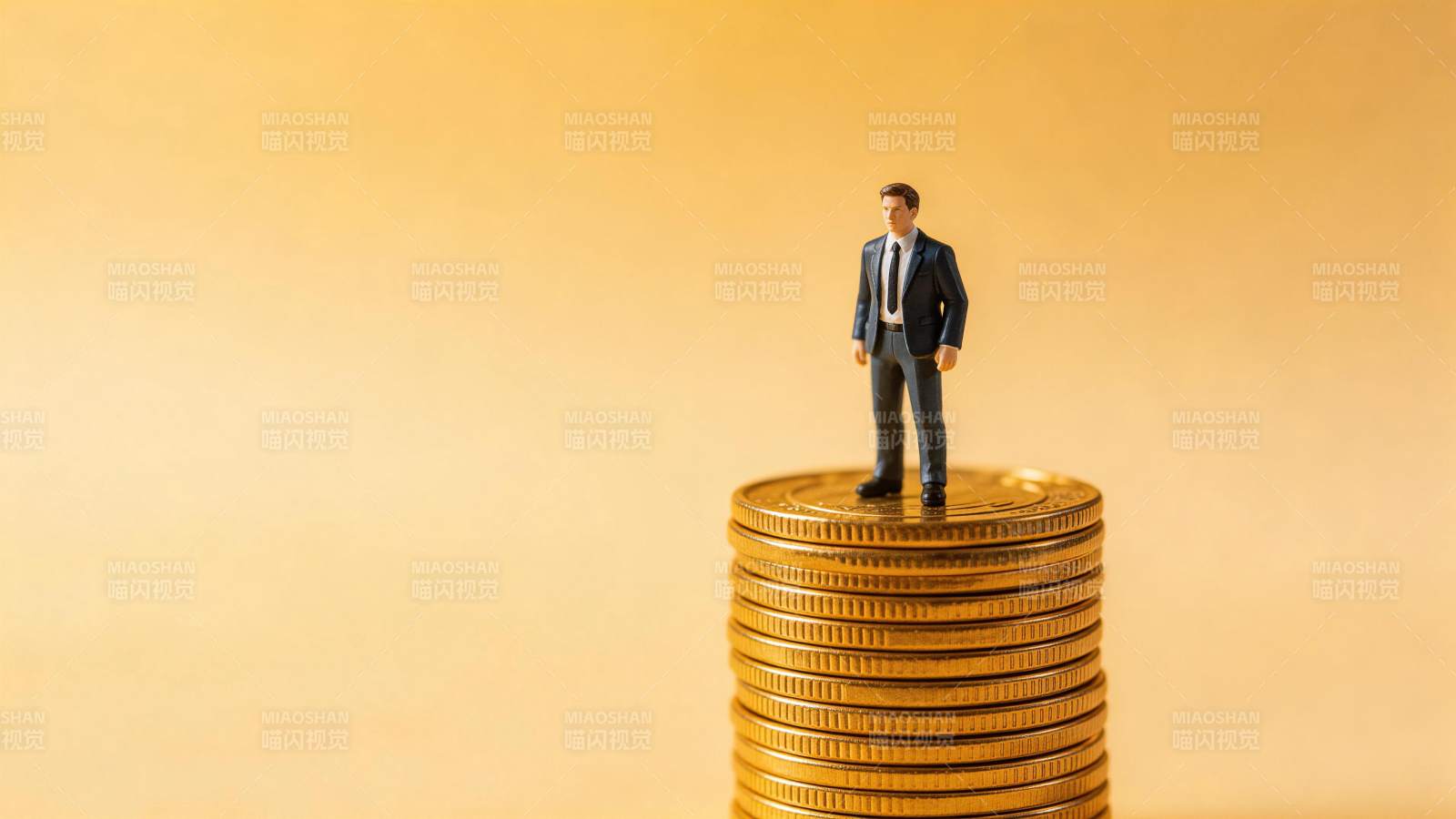 微型西装男子站立在金币堆顶端图片