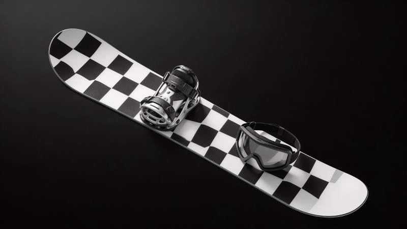 黑白棋盘格单板滑雪板与护目镜特写图片
