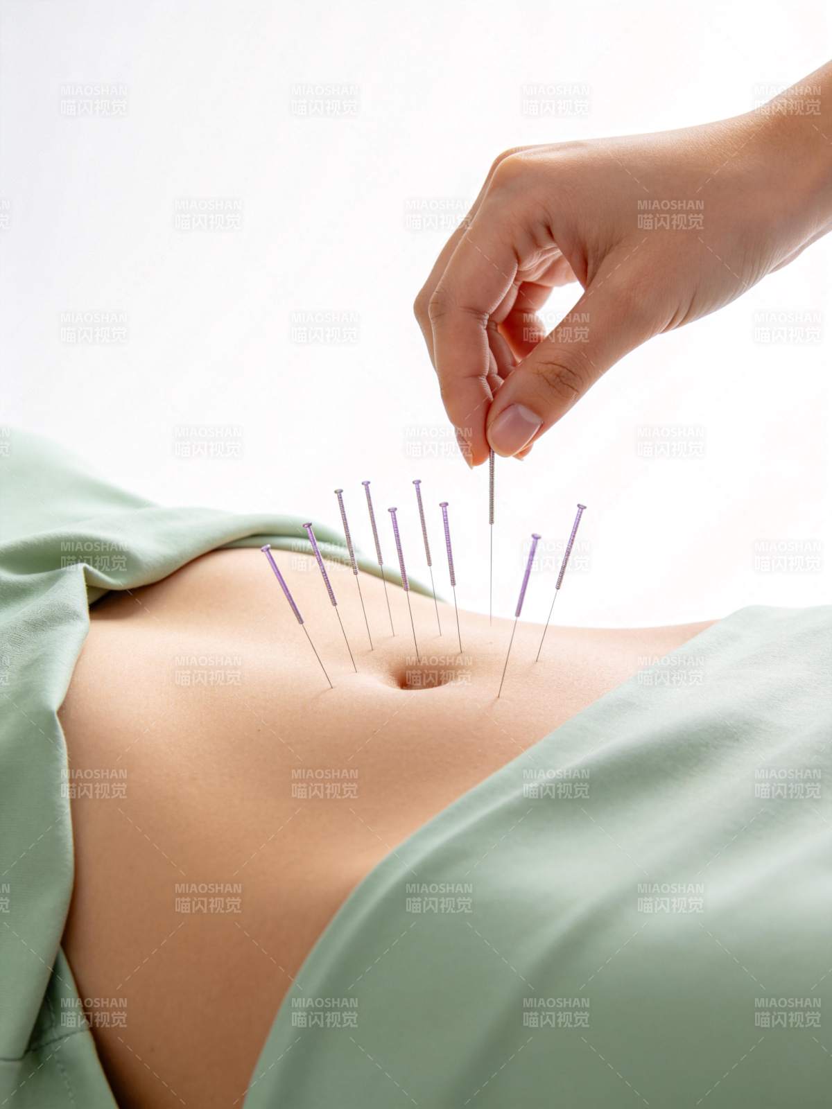 腹部针灸治疗场景手部持针操作特写图片