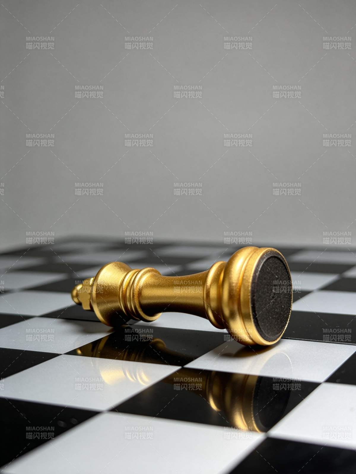 金色国际象棋王棋倒卧在黑白棋盘上图片