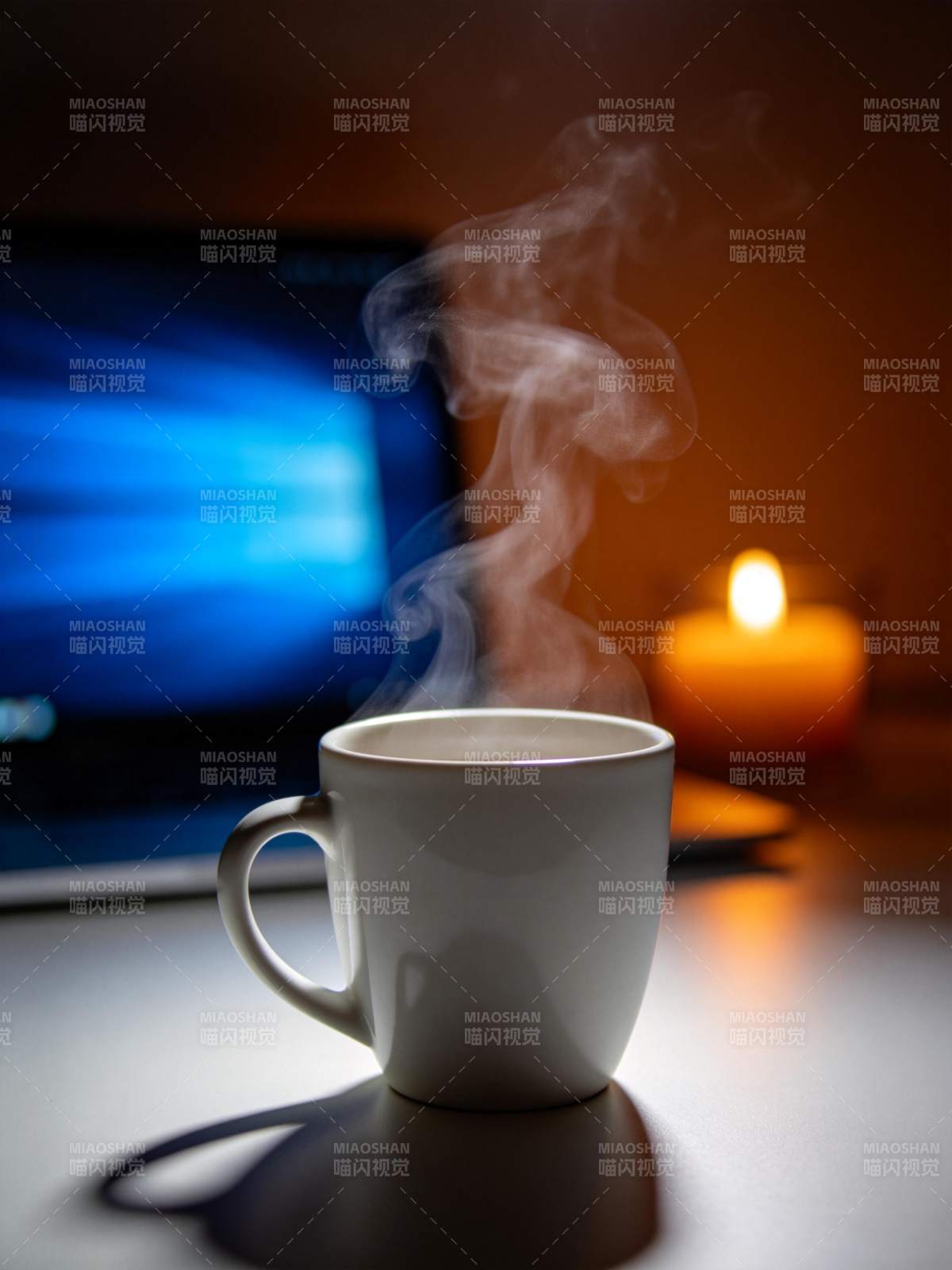 白色瓷杯热气升腾置于桌面电脑旁图片