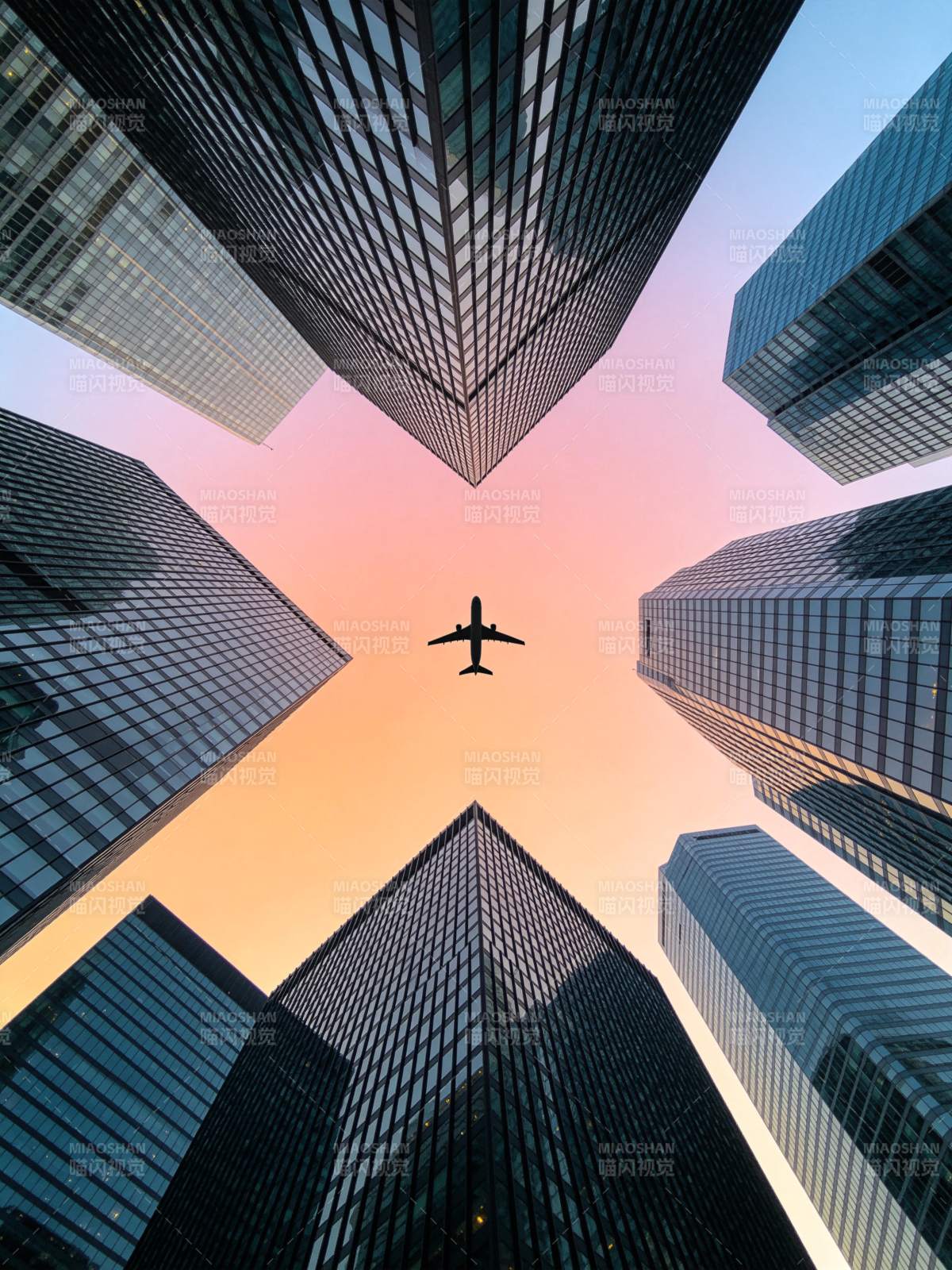 高楼林立间飞行的客机剪影图片