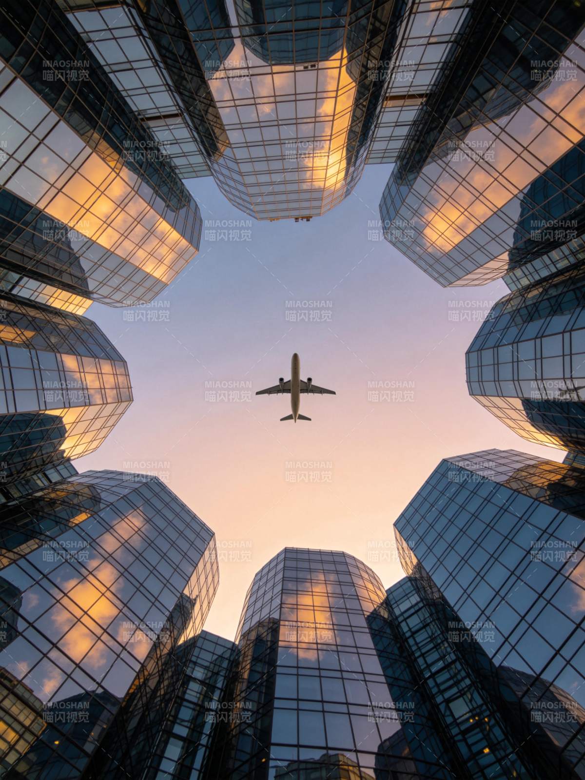 玻璃幕墙高楼环绕中飞机飞越城市上空图片