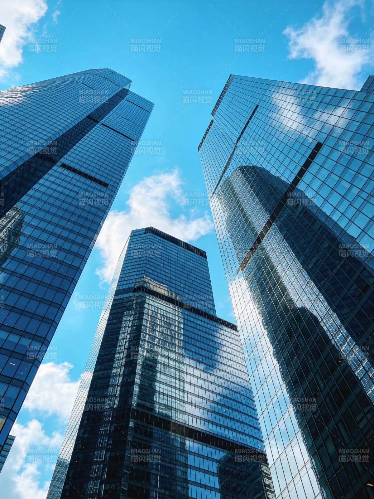 仰拍视角下的现代玻璃幕墙摩天大楼群图片