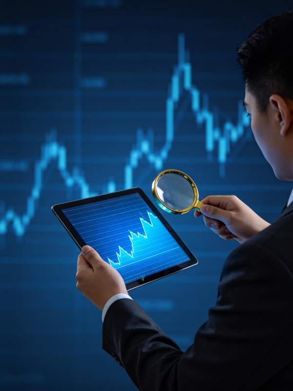 商务人士用放大镜分析平板上的数据图表图片